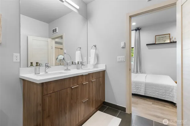 a en suite bathroom with a double vanity sink and a mirror