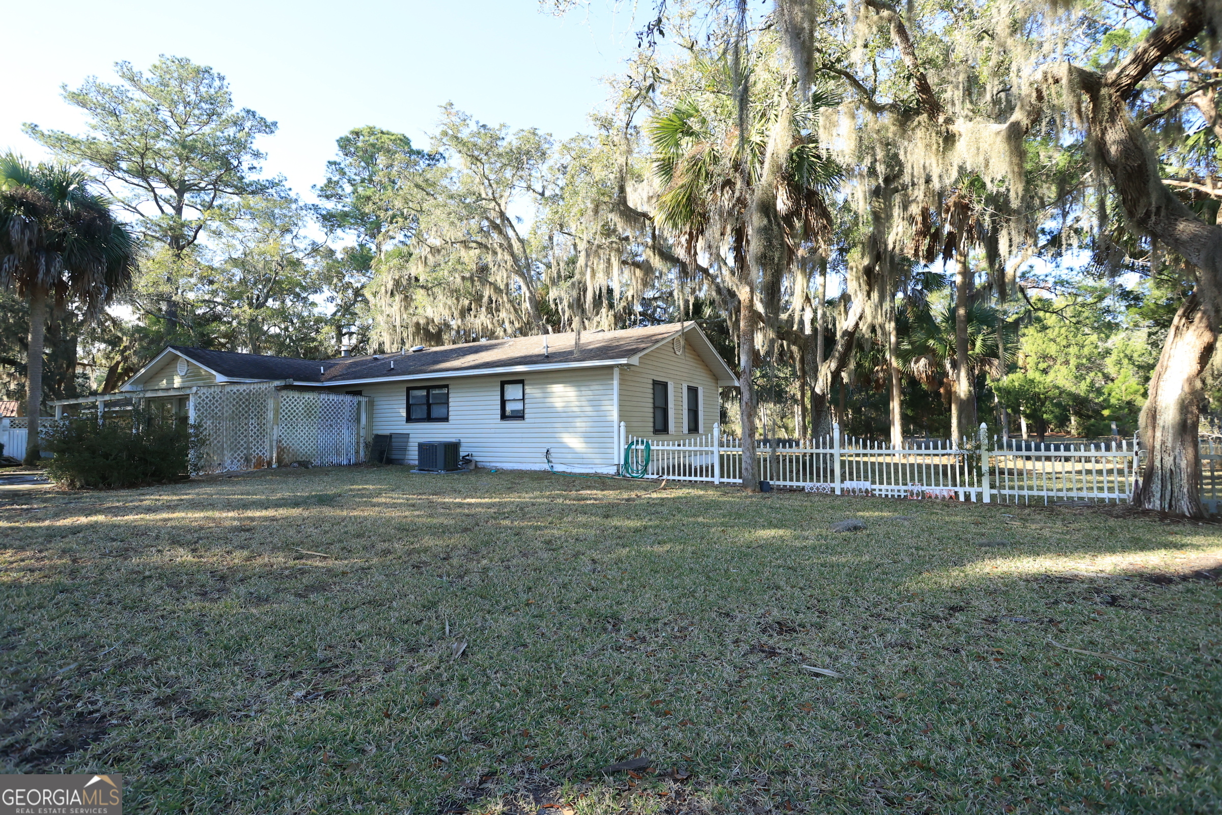a view of a yard in front of a house with large trees