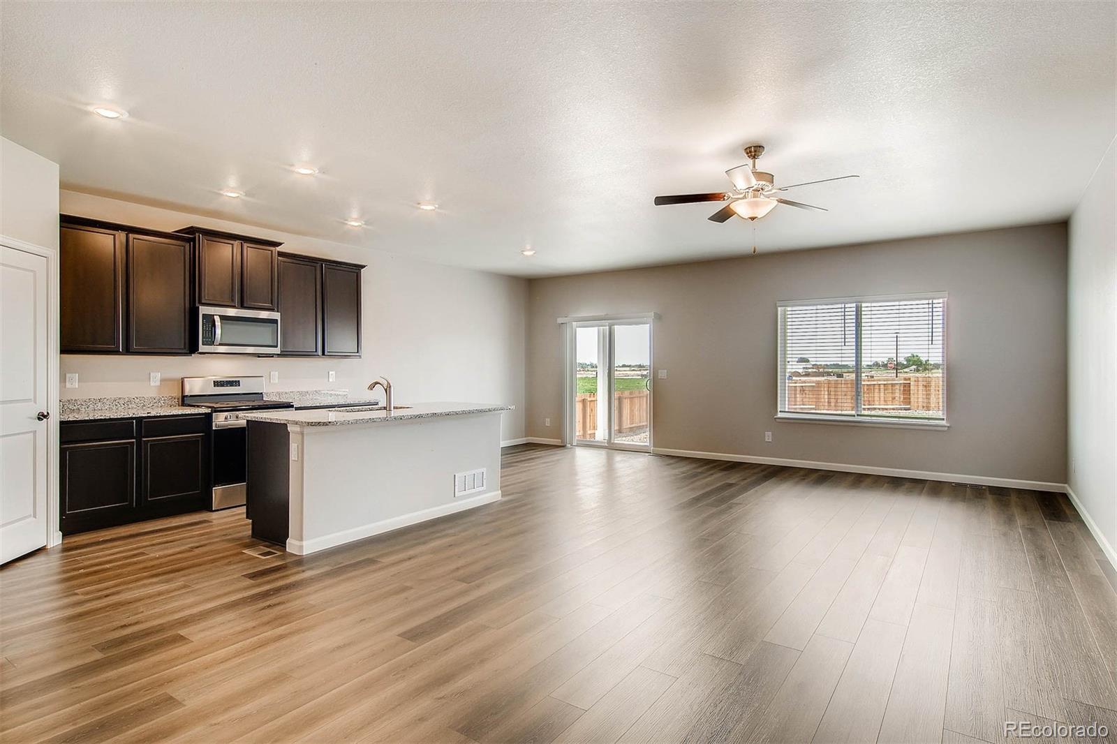 2299 Murray Street Mead, CO 80504 - Photo 12 of 17 a large kitchen with stainless steel appliances a large counter top a stove and a wooden floor