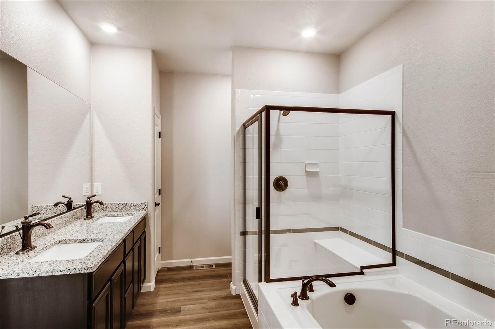2299 Murray Street Mead, CO 80504 - Photo 5 of 17 a bathroom with a granite countertop sink a mirror and shower