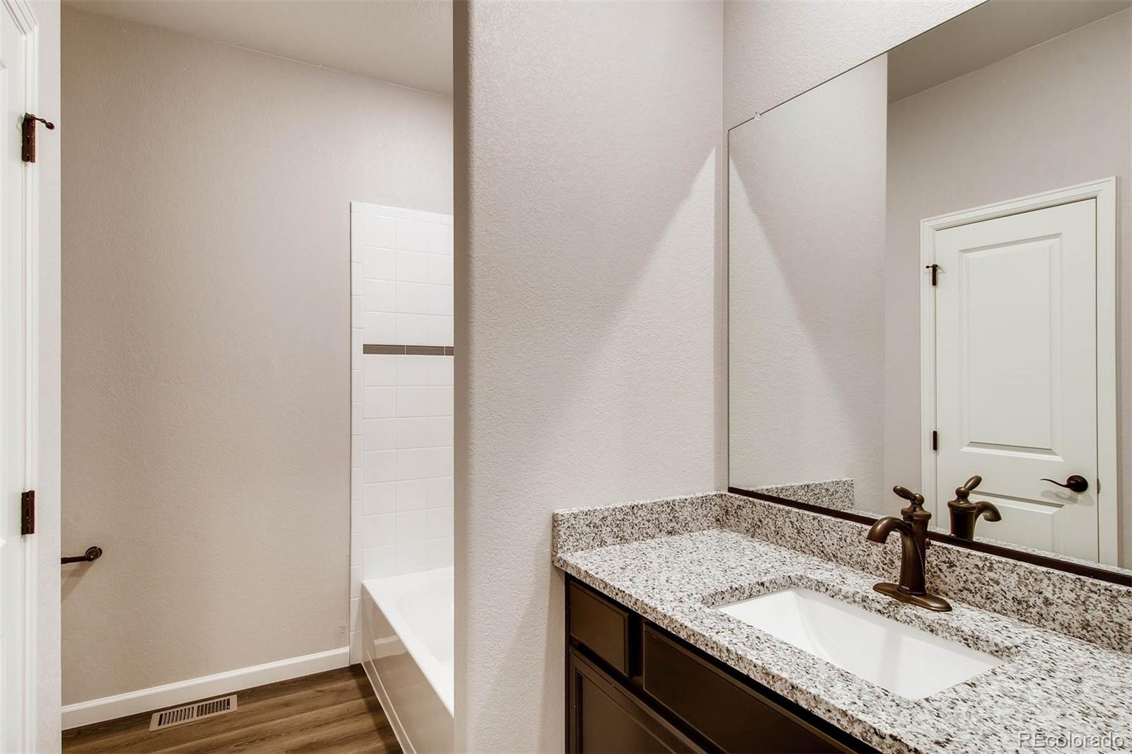 2299 Murray Street Mead, CO 80504 - Photo 8 of 17 a bathroom with a granite countertop sink and a mirror
