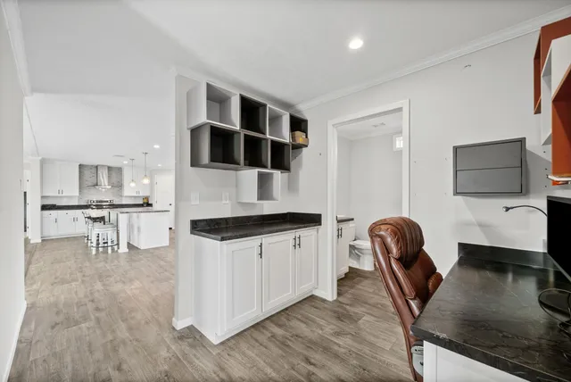 a kitchen with stainless steel appliances kitchen island granite countertop a microwave a stove and white cabinets