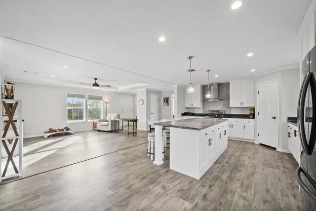 a large white kitchen with lots of counter top space and stainless steel appliances