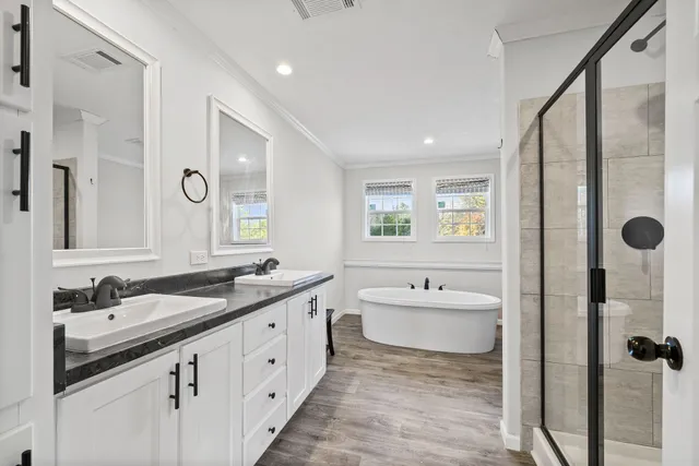 a spacious bathroom with a double vanity sink double mirror and bathtub