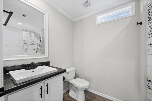 a bathroom with a sink toilet and a mirror