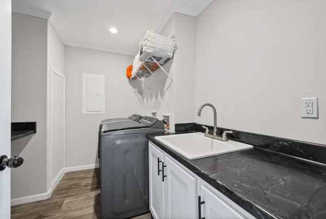 a view of a sink and dishwasher with wooden floor