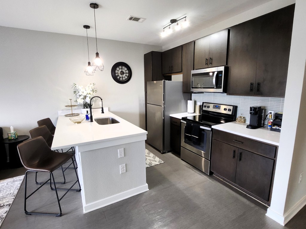 2505 Thornton Road, Unit 2307 Austin, TX 78704 - Photo 1 of 36 a kitchen with stainless steel appliances granite countertop a sink a stove and a refrigerator