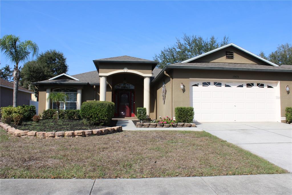 13475 Teaberry Lane Spring Hill, FL 34609 - Photo 1 of 21 front view of a house with a yard