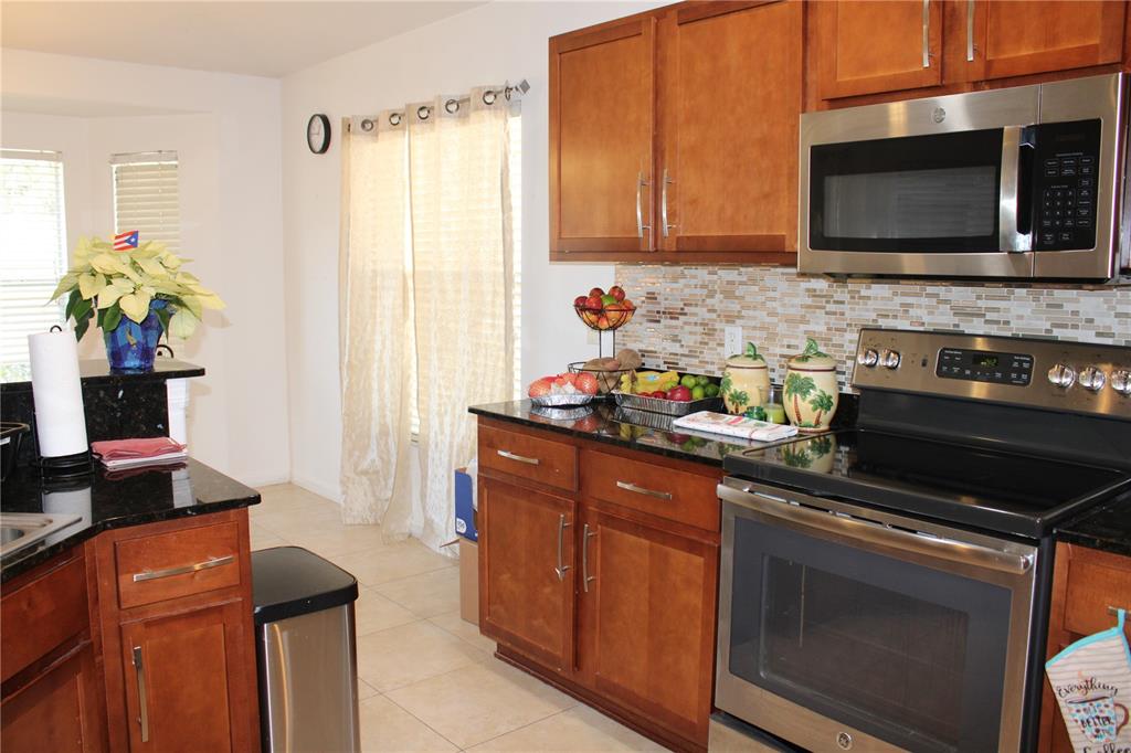 13475 Teaberry Lane Spring Hill, FL 34609 - Photo 11 of 21 a kitchen with stainless steel appliances a stove microwave and cabinets