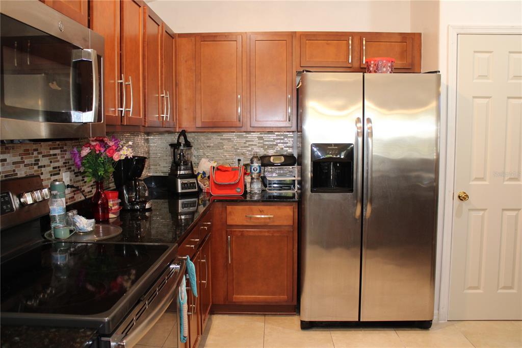 13475 Teaberry Lane Spring Hill, FL 34609 - Photo 10 of 21 a kitchen with a refrigerator and microwave