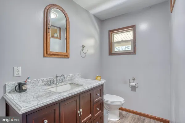 an empty room with wooden floor closet and windows