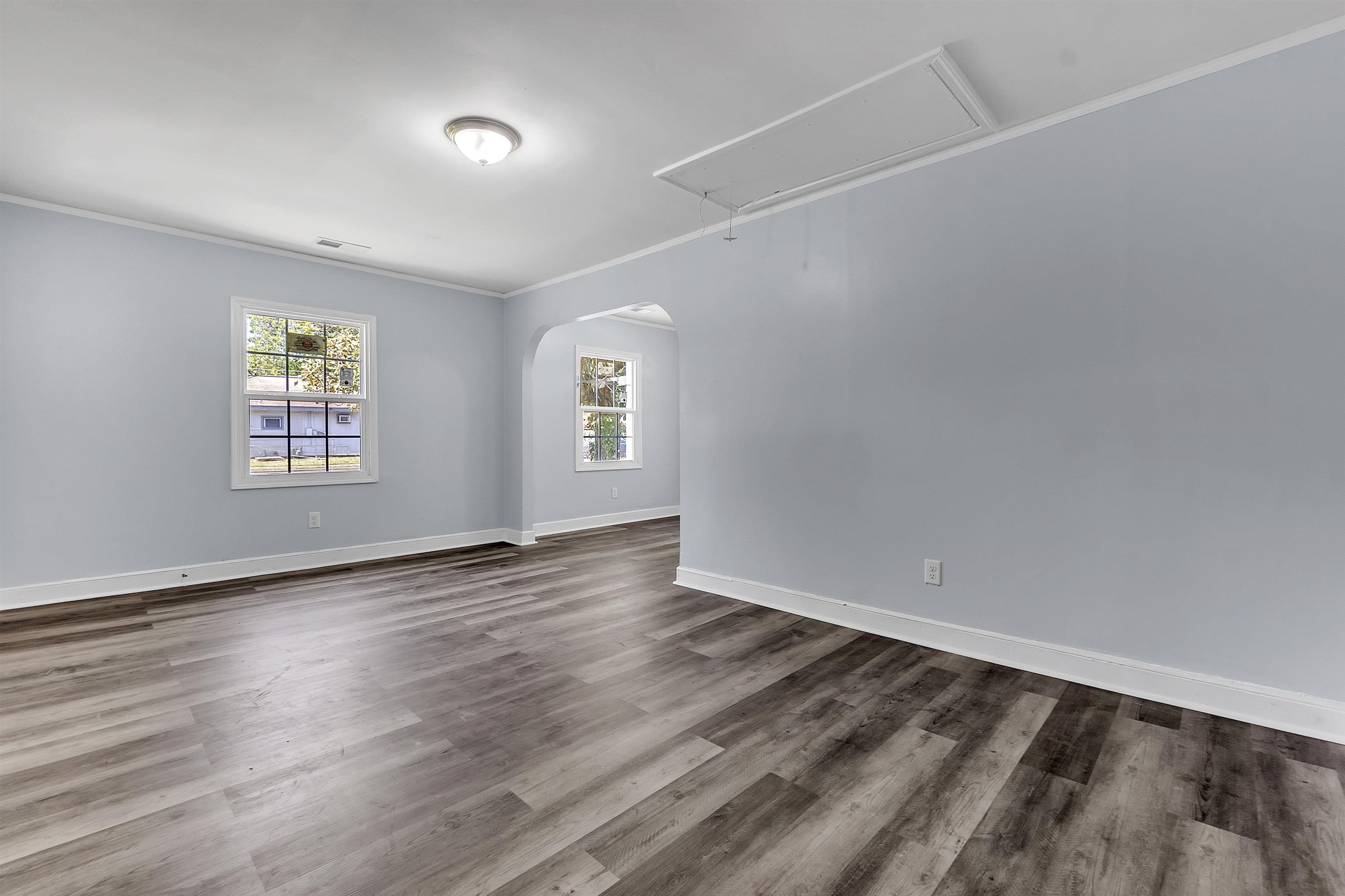 1682 Pendleton Street Memphis, TN 38114 - Photo 7 of 36 an empty room with wooden floor and windows