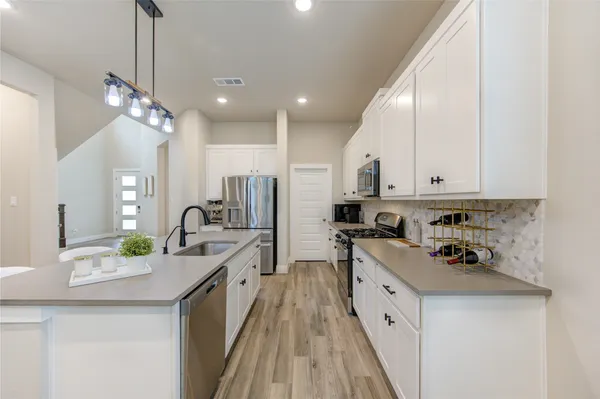 a large kitchen with granite countertop lots of counter space and sink