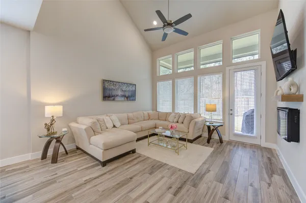a living room with furniture a large window and a flat screen tv