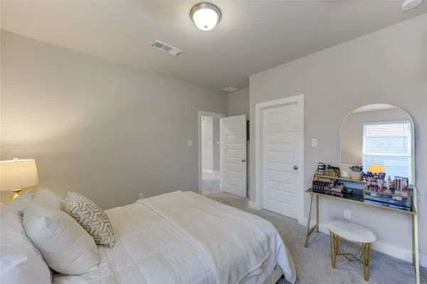 a bedroom with a bed and a mirror on the dresser