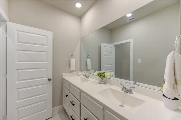 a bathroom with a double vanity sink and a mirror