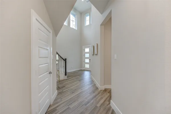 a view of a hallway with wooden floor and staircase