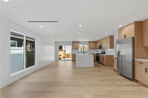 a large kitchen with kitchen island a refrigerator a sink dishwasher with a stove and refrigerator