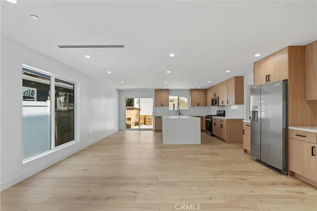 a large kitchen with kitchen island a refrigerator a sink dishwasher with a stove and refrigerator