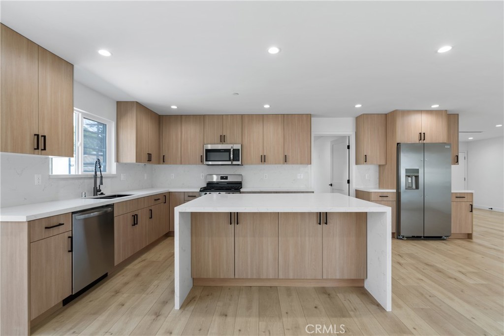 13901 Runnymede Street Van Nuys, CA 91405 - Photo 12 of 47 a large kitchen with stainless steel appliances a sink a stove a refrigerator and cabinets