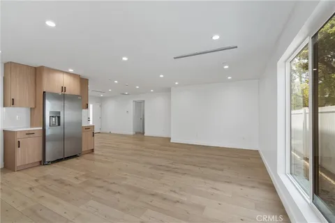 a view of empty room with wooden floor and windows