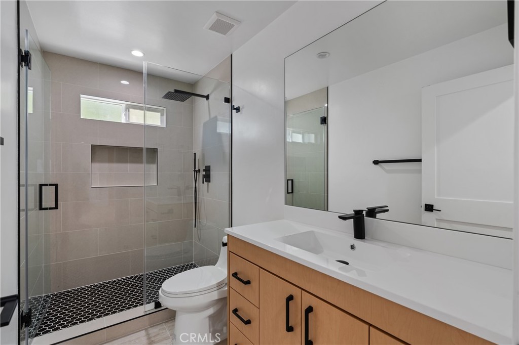 13901 Runnymede Street Van Nuys, CA 91405 - Photo 20 of 47 a bathroom with a sink toilet a mirror and shower