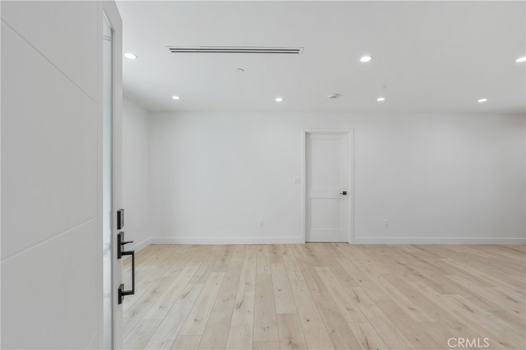 13901 Runnymede Street Van Nuys, CA 91405 - Photo 23 of 47 an empty room with wooden floor and a ceiling fan