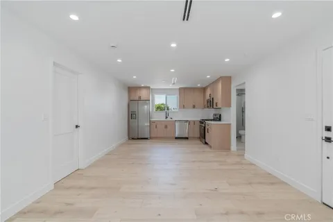 a kitchen with stainless steel appliances a refrigerator sink and white cabinets