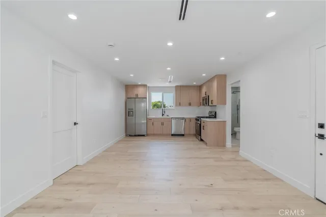 a kitchen with stainless steel appliances a refrigerator sink and white cabinets