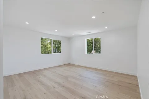 an empty room with large windows and natural light