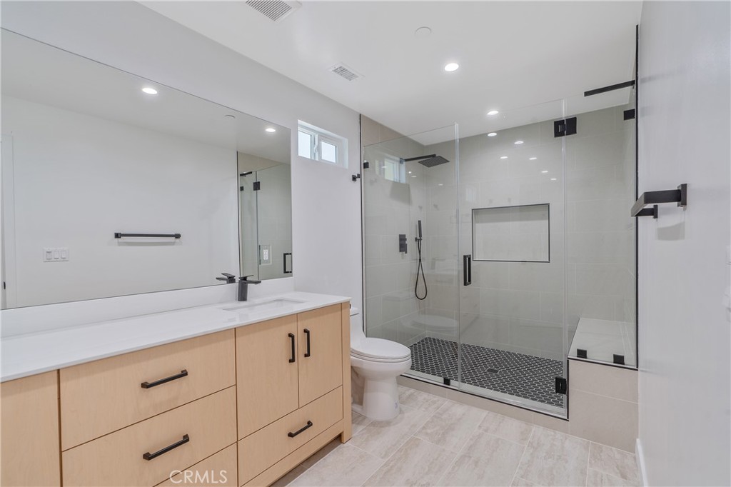 13901 Runnymede Street Van Nuys, CA 91405 - Photo 32 of 47 a spacious bathroom with a granite countertop sink a toilet a mirror and shower