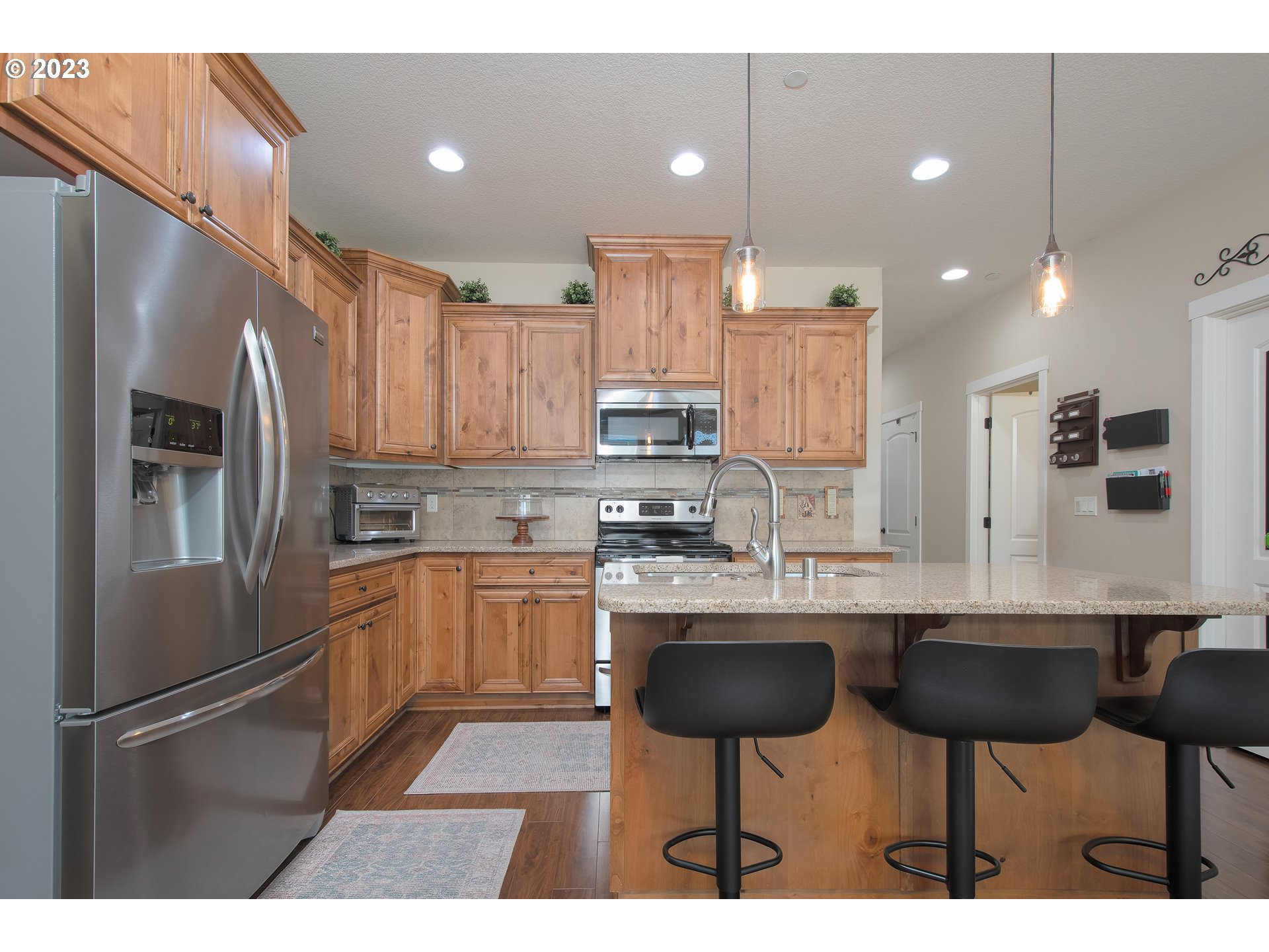 3309 North 3rd Street Ridgefield, WA 98642 - Photo 7 of 36 a kitchen with stainless steel appliances granite countertop a refrigerator sink and cabinets
