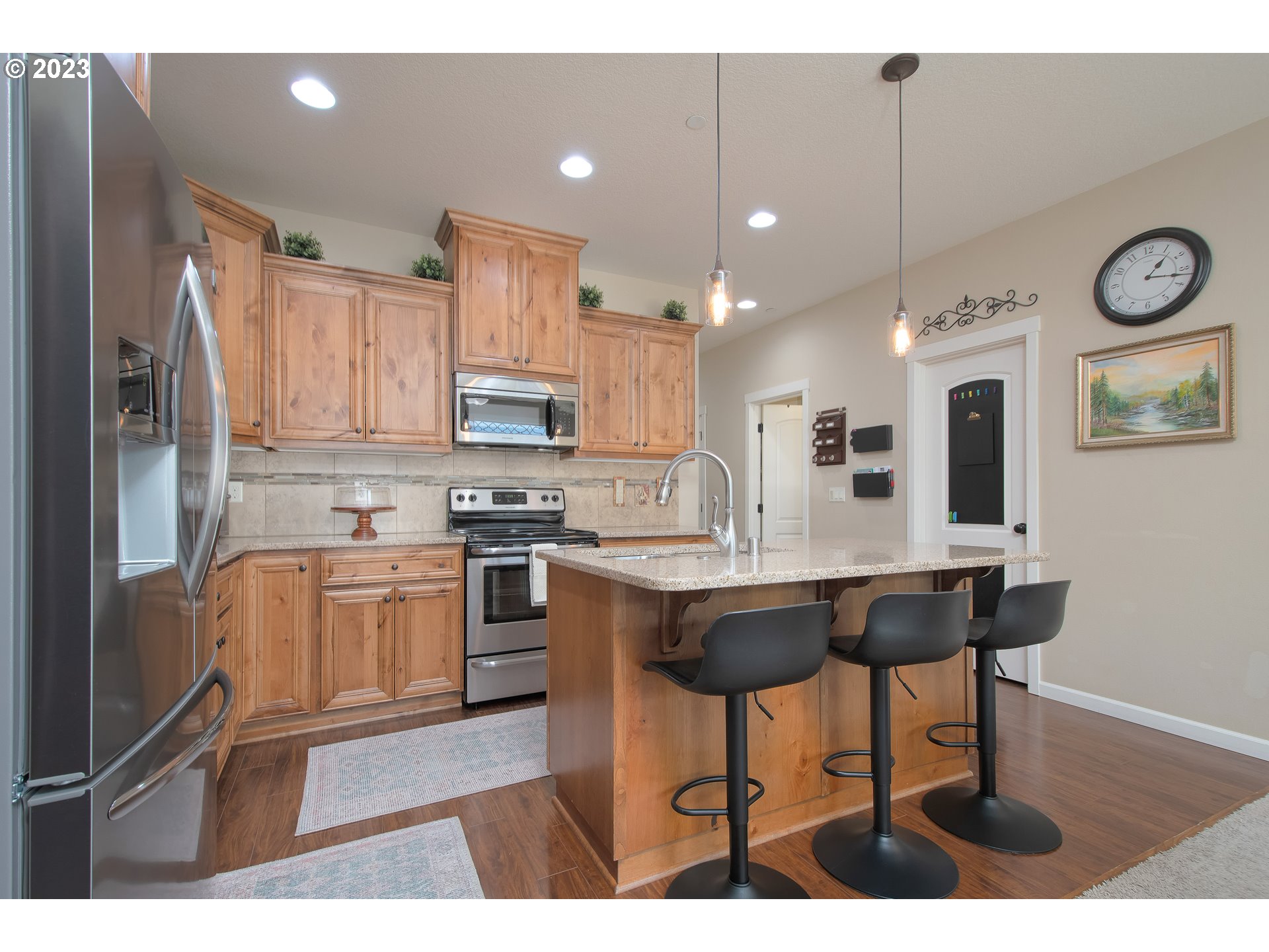 3309 North 3rd Street Ridgefield, WA 98642 - Photo 8 of 36 a kitchen with stainless steel appliances granite countertop a sink a stove a refrigerator cabinets and a dining table