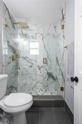 a bathroom with a toilet and a shower