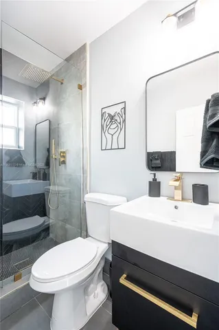 a bathroom with a sink a toilet and shower