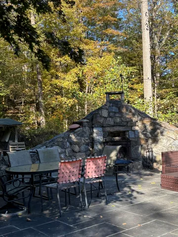 a patio with table and chairs and potted plants