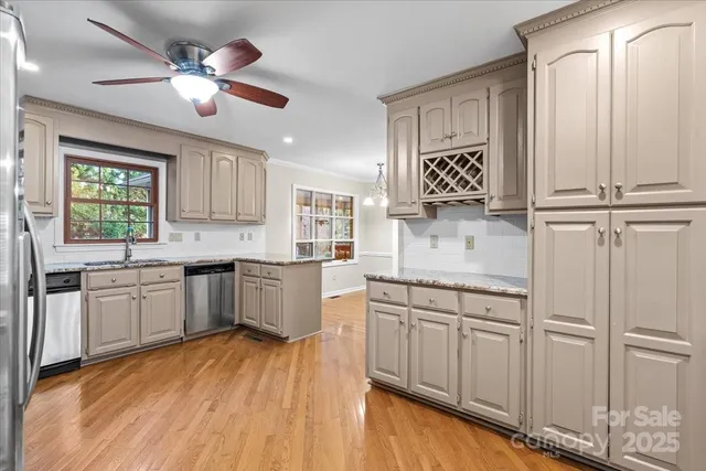 a kitchen with white cabinets stainless steel appliances and a window