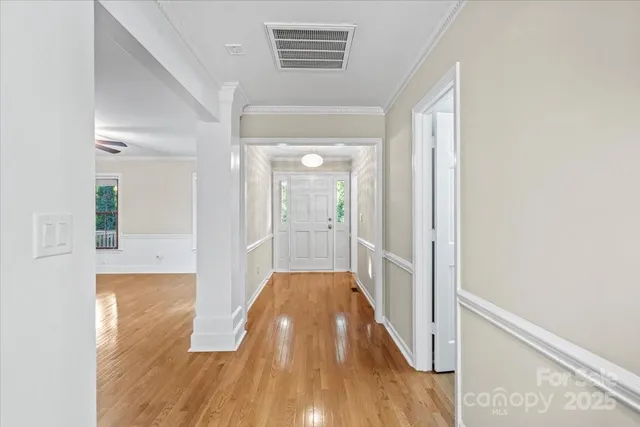 a view of a hallway with wooden floor and a window