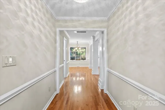 a view of a livingroom with wooden floor a ceiling fan and windows