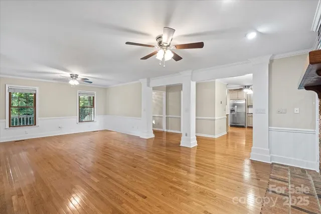 a kitchen with stainless steel appliances granite countertop a refrigerator a sink dishwasher a stove and white cabinets with wooden floor