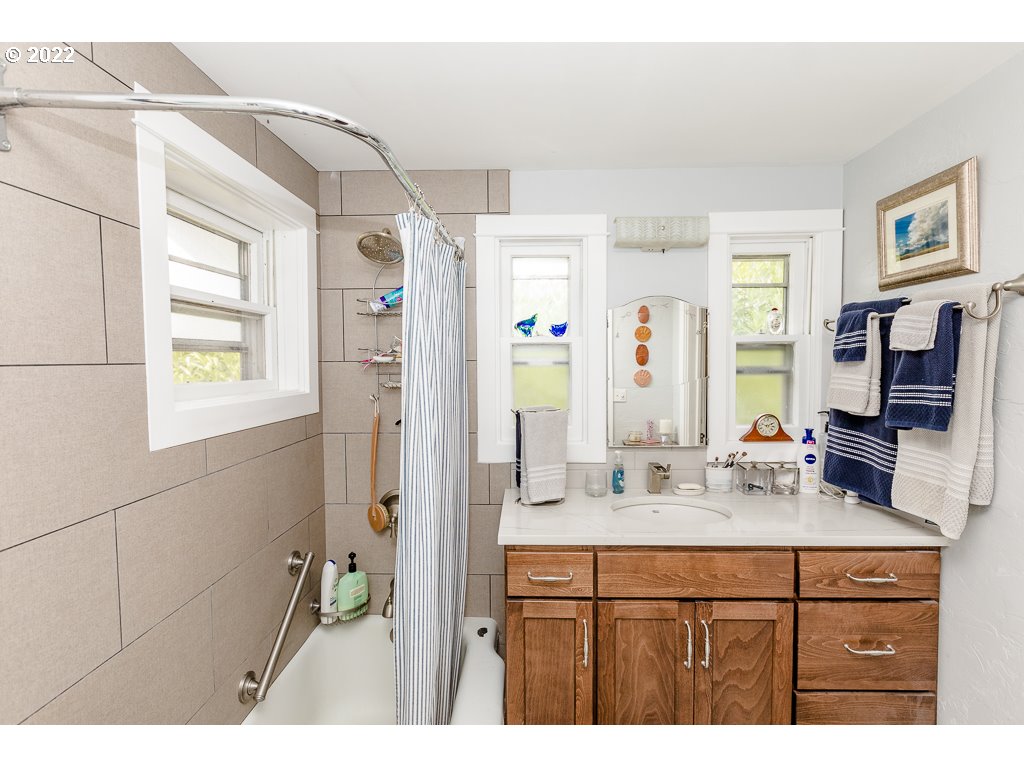 904 E Street Springfield, OR 97477 - Photo 20 of 31 a bathroom with a sink a mirror and a shower