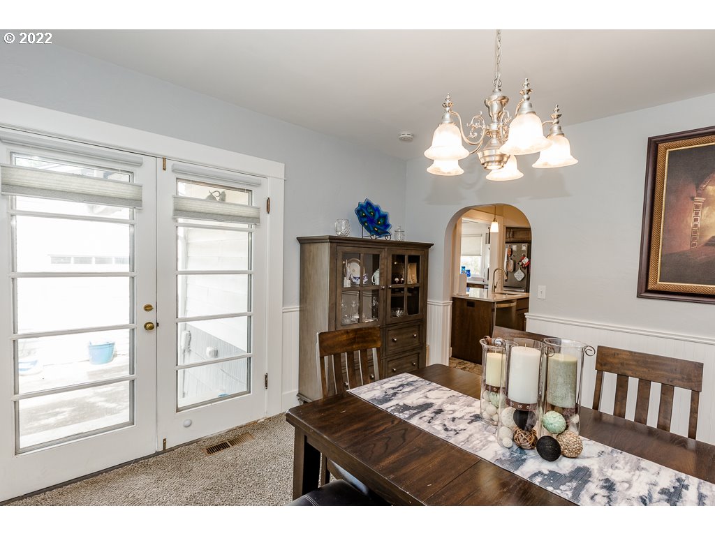 904 E Street Springfield, OR 97477 - Photo 9 of 31 a dining room with wooden floor a chandelier a wooden table and chairs