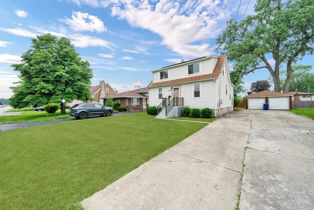 a front view of a house with a garden and trees