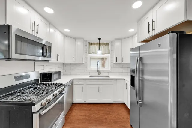 a kitchen with a stove a sink and a refrigerator
