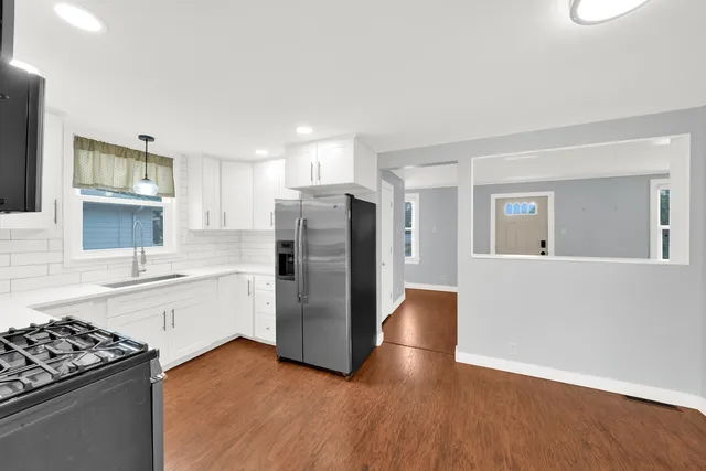 a kitchen with a refrigerator and a stove top oven