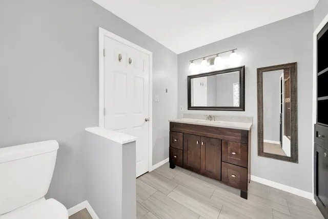 a bathroom with a toilet a sink and mirror