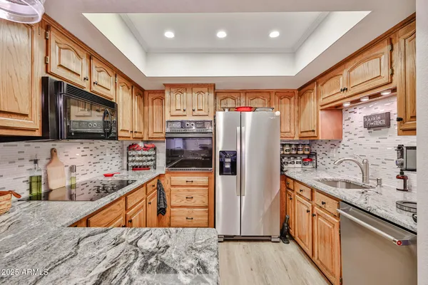 a kitchen with stainless steel appliances granite countertop a refrigerator a stove top oven a sink and dishwasher