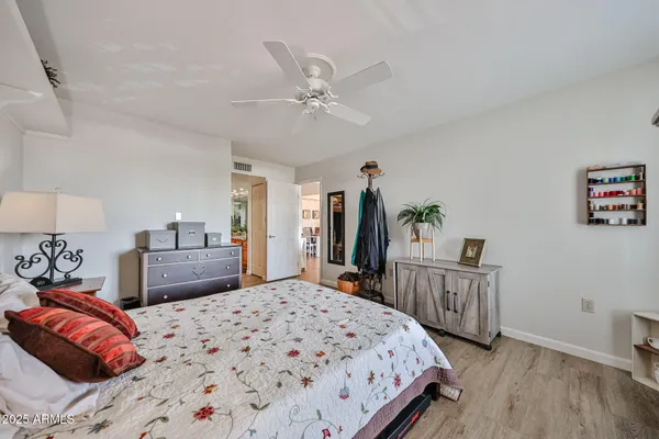 a bedroom with a large bed and a chandelier