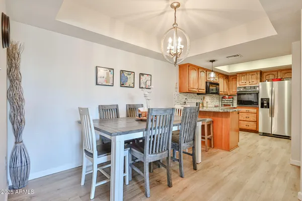 a view of a dining room with furniture a chandelier and wooden floor