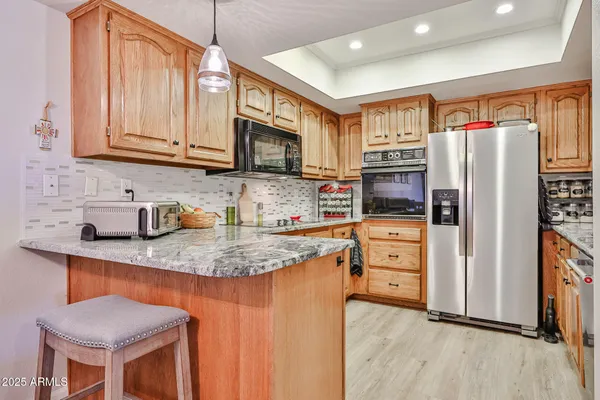 a kitchen with stainless steel appliances granite countertop a refrigerator and a stove top oven